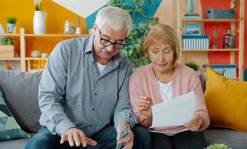 Old couple sat together reading documents