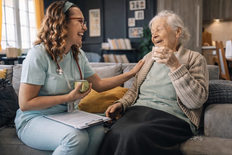 Smiling nurse talking to smiling elderly person